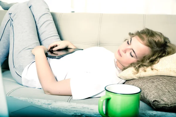 Mujer durmiendo por la noche con un Tablet PC en el sofá — Foto de Stock