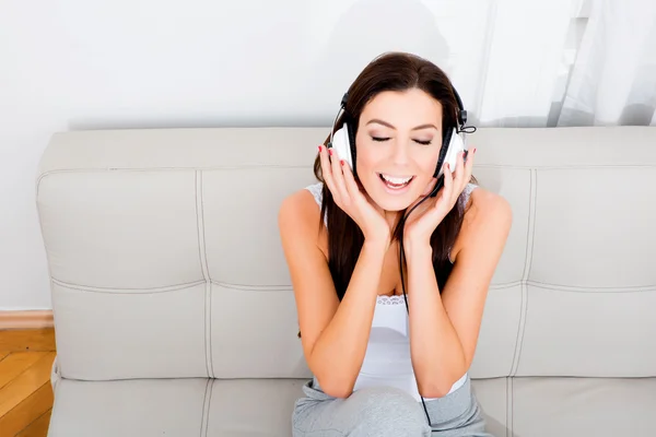 Молодая красивая женщина слушает аудио — стоковое фото