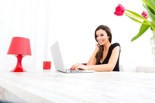 Jonge mooie vrouw met behulp van een laptop thuis — Stockfoto