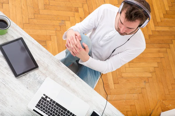 Ung man lyssnar musik på hans Laptop — Stockfoto