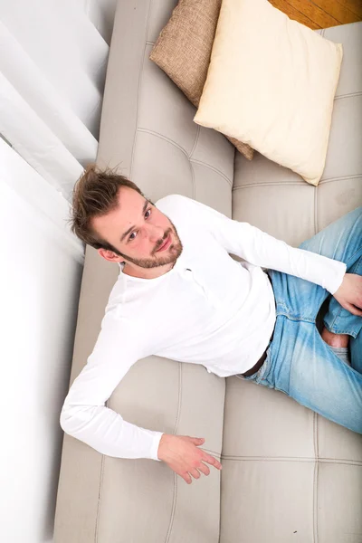 Hombre joven relajándose en el sofá — Foto de Stock