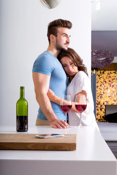 Jovem casal beber vinho na cozinha — Fotografia de Stock
