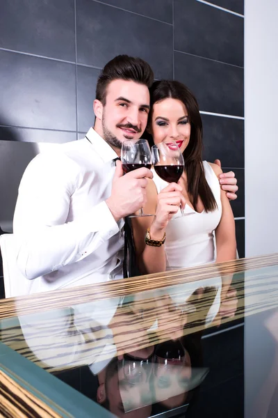 A romantic couple with a glass of wine in the dining room — Stock Photo, Image