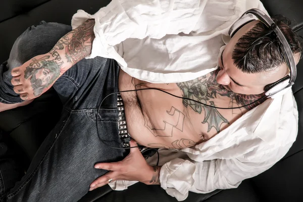 Tattooed man on the sofa — Stock Photo, Image