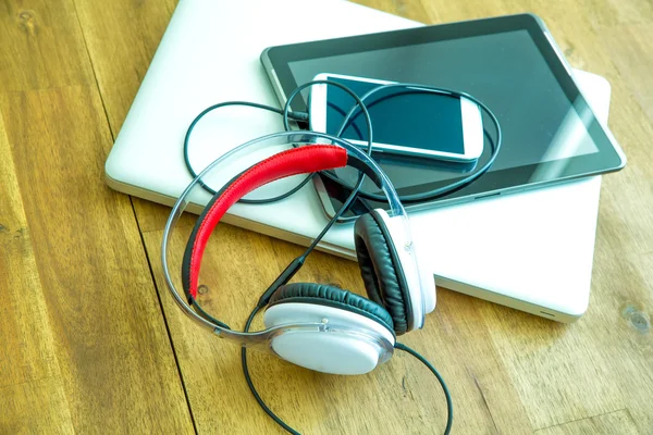 Digital devices and Headphones on a wooden Desktop — Stock Photo, Image