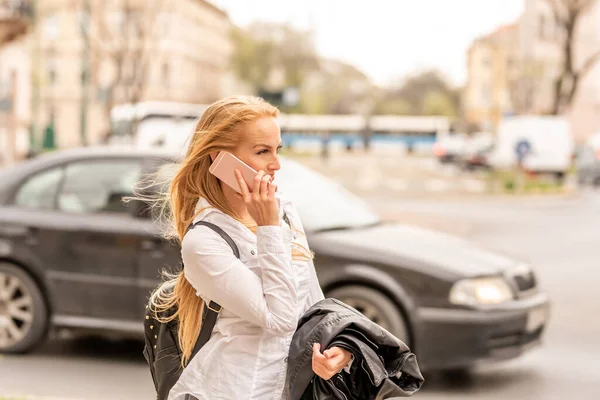 Una mujer hablando por teléfono mientras camina — Foto de Stock