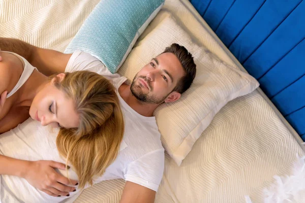 Молодая пара лежит на кровати — стоковое фото