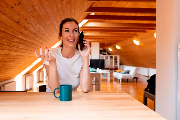 Eine schöne Frau telefoniert in der Küche. — Stockfoto