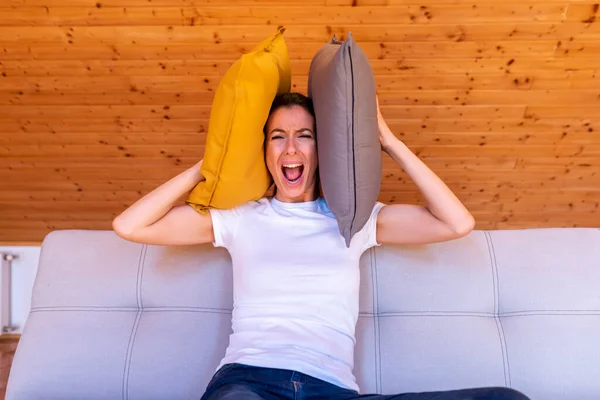Una mujer jugando con almohadas en el sofá — Foto de Stock