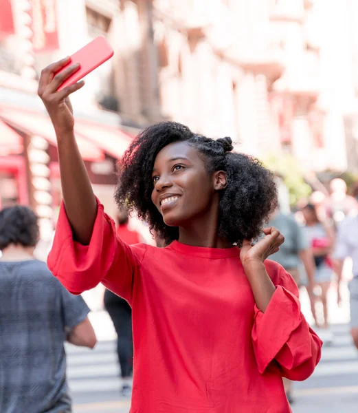 Uma jovem mulher adulta tirando selfies na cidade — Fotografia de Stock