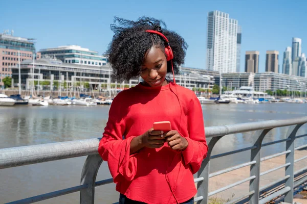 A woman listening to music on her headphones in a urban environment — Stock Photo, Image