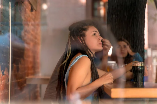 Uma jovem mulher com dreadlocks em um bar — Fotografia de Stock