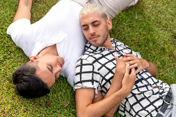 Jong gay paar liggend op het gras in een openbaar park — Stockfoto