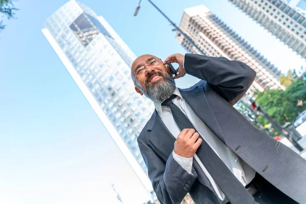 Asiatischer Geschäftsmann telefoniert an der Skyline einer Großstadt lizenzfreie Stockfotos