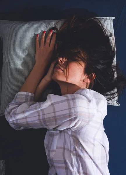 Een slaperige jonge vrouw in bed 's nachts — Stockfoto