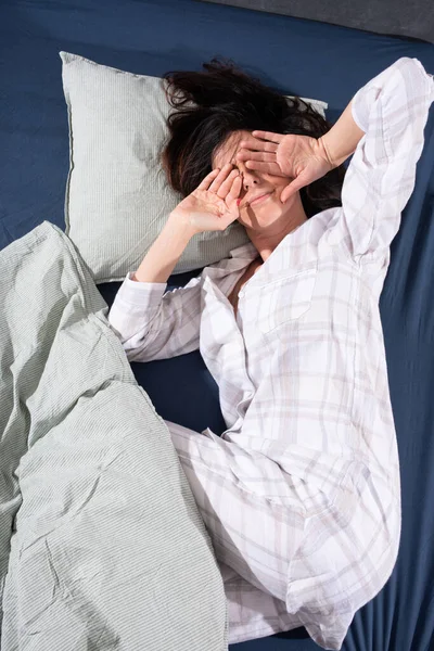 Una joven somnolienta en la cama por la mañana — Foto de Stock