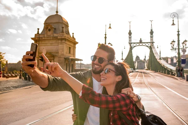A traveling couple taking a selfie in Budapest