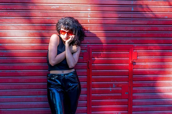 Mujer joven de pie en el fondo rojo — Foto de Stock