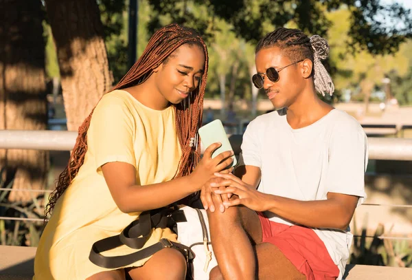 Um casal feliz se divertindo enquanto tira selfies em um parque de uma cidade grande — Fotografia de Stock