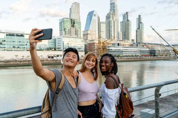 Jovens amigos tirando selfies à beira do rio — Fotografia de Stock