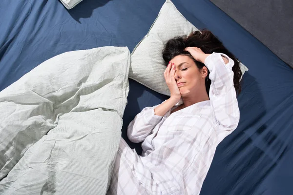 Een slaperige jonge vrouw in bed in de ochtend — Stockfoto