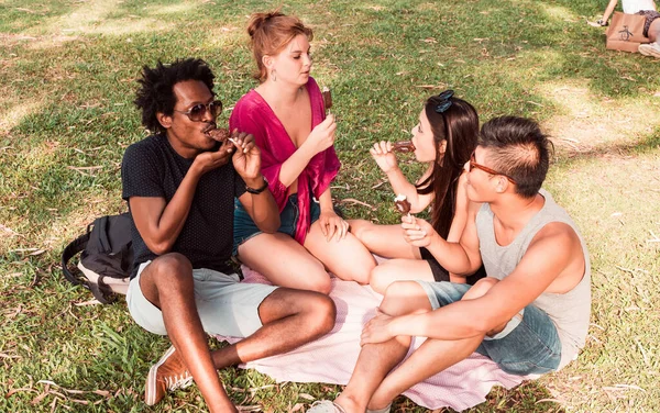 Un grupo de amigos comiendo helado juntos en un parque —  Fotos de Stock