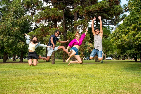 Щасливі друзі стрибають в парку — стокове фото