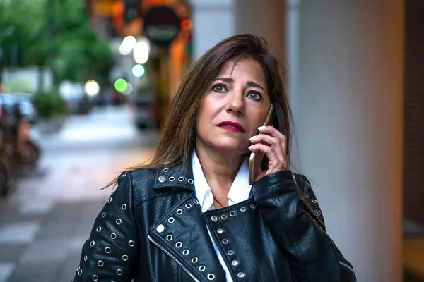 Uma mulher madura séria falando em seu telefone — Fotografia de Stock