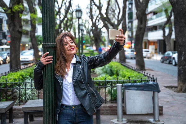 Una donna matura sorridente che si fa un selfie Fotografia Stock