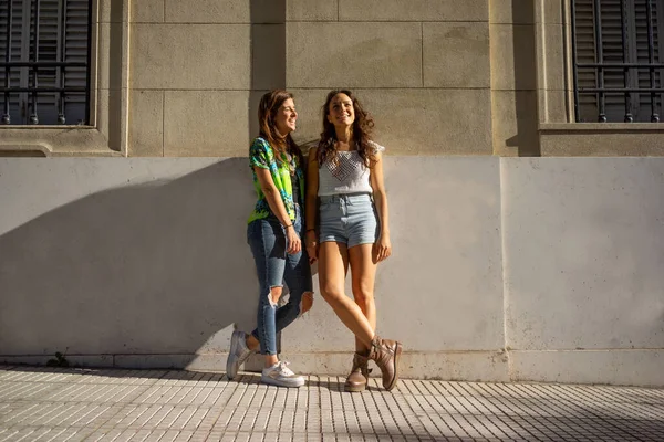 Жінки-друзі стоять біля стіни на вулиці Ліцензійні Стокові Фото