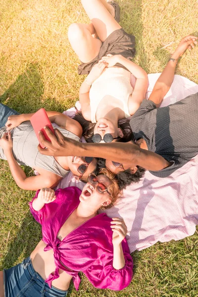 Φίλοι που βγάζουν selfies ενώ ξαπλώνουν στο γρασίδι — Φωτογραφία Αρχείου