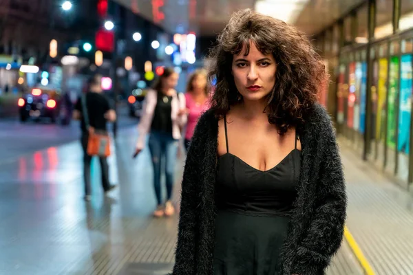 Serious latin woman standing on the street at night — Fotografia de Stock