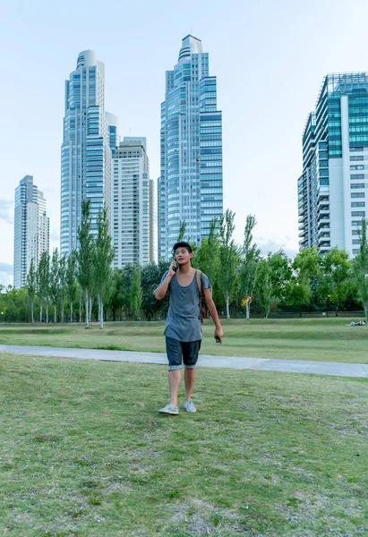 Joven asiático chico hablando por teléfono en un parque — Foto de Stock