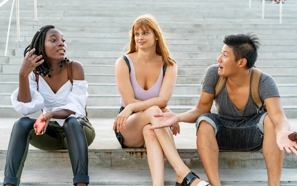 Arguing friends sitting on the stairs — Stock Photo, Image