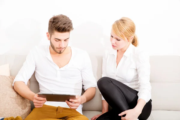 Young couple talking on the sofa — Stock Photo, Image