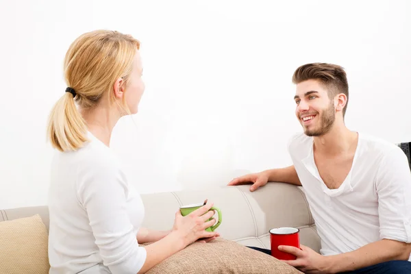 Casal jovem conversando no sofá — Fotografia de Stock