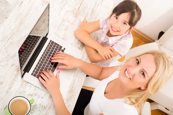 Mère et fille avec un ordinateur portable à la maison — Photo