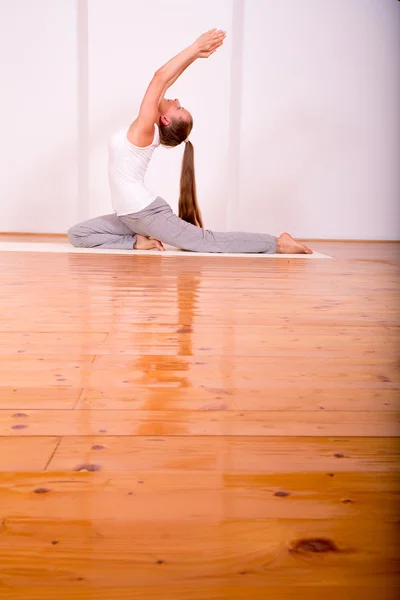 Femme pratiquant le yoga dans un studio — Photo