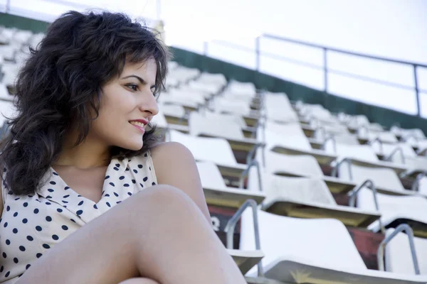 Ретро девушка, сидящая на стадионе — стоковое фото