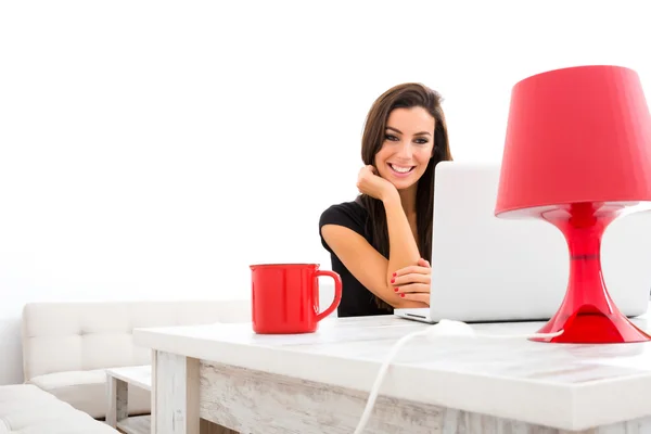 Young beautiful woman happily using a Laptop at home — Stock Photo, Image