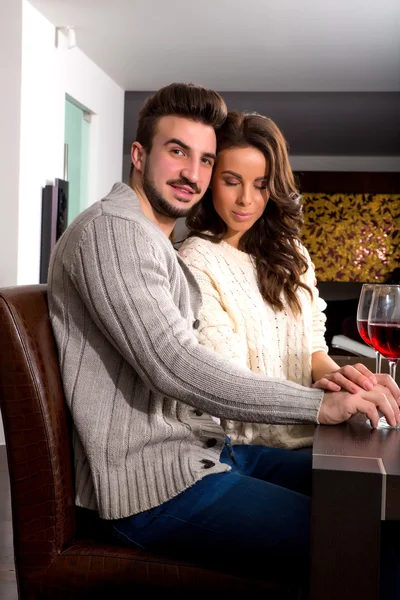 Молода пара насолоджується келихом вина вдома — стокове фото