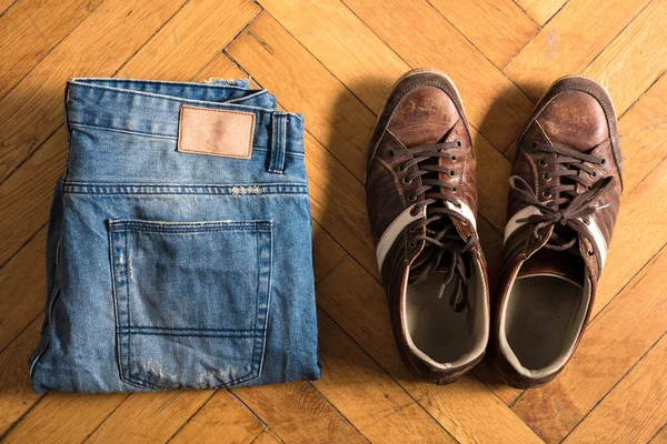 Shoes and jeans on the floor — Stock Photo, Image