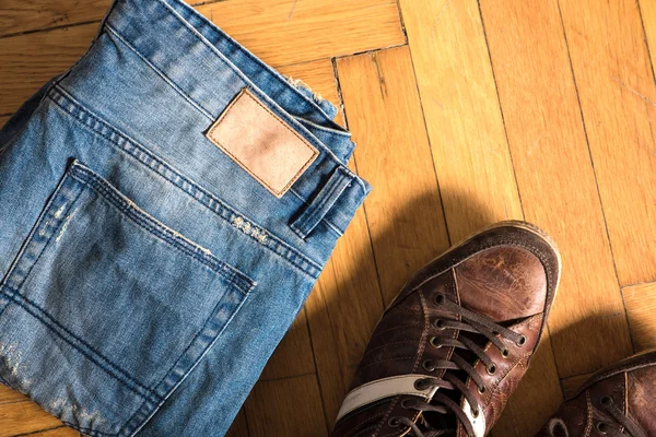 Shoes and jeans on the floor — Stock Photo, Image