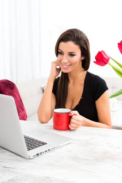 Jonge mooie vrouw met behulp van een laptop thuis — Stockfoto