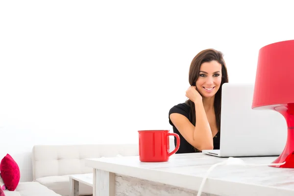 Jovem mulher bonita feliz usando um laptop em casa — Fotografia de Stock