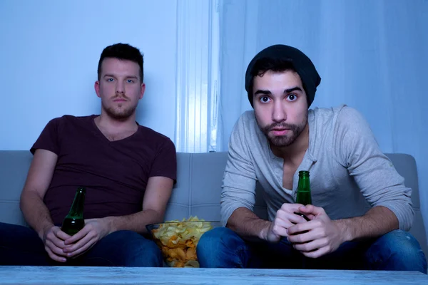 Two Friends watching passionately TV with Beer and Chips — Stock Photo, Image