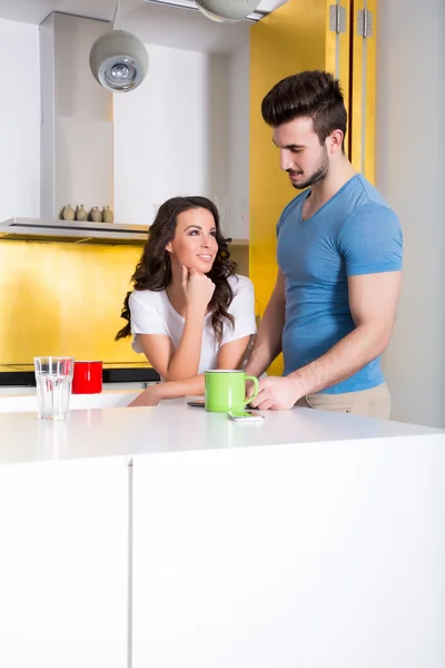 Casal jovem usando um Tablet PC na cozinha em casa — Fotografia de Stock