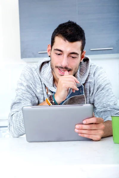 Jovem com tablet na cozinha — Fotografia de Stock