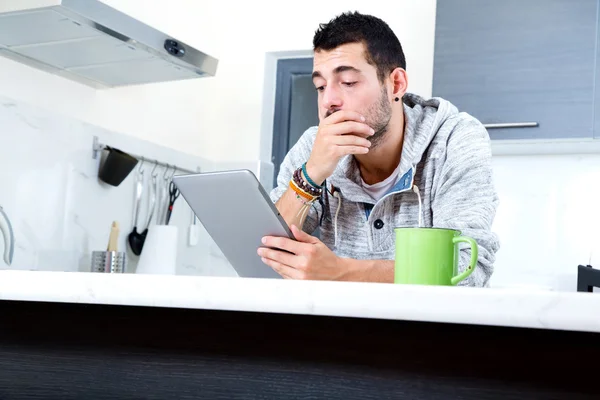 Mutfakta tablet ile genç adam — Stok fotoğraf