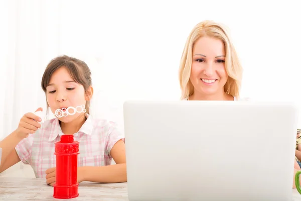 Madre e figlia con un computer portatile a casa — Foto Stock